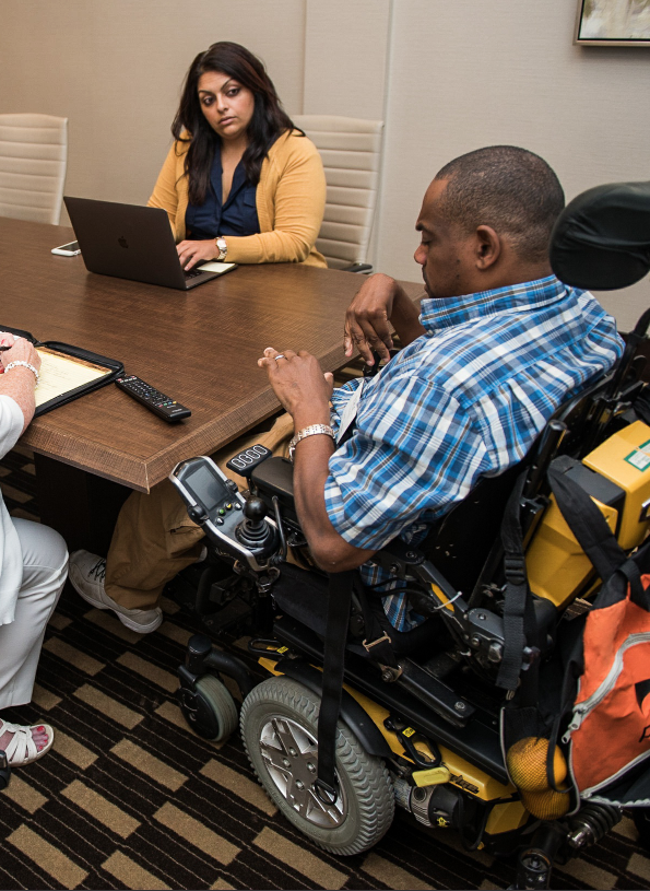 Employee with disabilities in wheelchair leading group discussion.