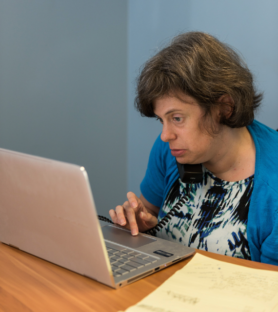 Woman with disabilities works on her laptop compter.